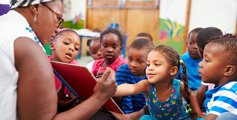 Image shows Black preschool students waiting for food while white classmates have their food served